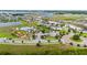 An aerial view showcasing the community pool, clubhouse, and playground, nestled among well-maintained homes and a lake at 2130 Bur Oak Blvd, St Cloud, FL 34771