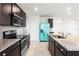 Modern kitchen with dark cabinetry, stainless steel appliances, granite countertops, and a turquoise refrigerator at 2130 Bur Oak Blvd, St Cloud, FL 34771