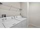 This laundry room includes a washer and dryer, storage shelf, and tile flooring at 2130 Bur Oak Blvd, St Cloud, FL 34771