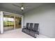 This patio area has chairs and a ceiling fan that leads to the backyard through a sliding glass door at 2130 Bur Oak Blvd, St Cloud, FL 34771