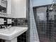 A traditional-styled bathroom with black tile and pedestal sink with shower at 2203 Beatrice Dr, Orlando, FL 32810