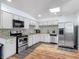 Bright kitchen featuring white cabinetry, modern stainless-steel appliances, and stylish backsplash at 2203 Beatrice Dr, Orlando, FL 32810