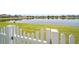 View of a well-manicured lawn and pond from behind a white picket fence at 2332 Andrews Valley Dr, Kissimmee, FL 34758
