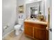 Cozy bathroom with light wood vanity, toilet, and standard mirror at 2332 Andrews Valley Dr, Kissimmee, FL 34758