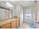 Bright bathroom with tan-tiled floors, window and single sink at 2332 Andrews Valley Dr, Kissimmee, FL 34758