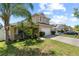 Side view of tan two-story home with attached garage, driveway and landscaped front yard at 2332 Andrews Valley Dr, Kissimmee, FL 34758