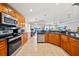 Open kitchen showcasing wooden cabinets, granite countertops, stainless appliances, and tile flooring at 2332 Andrews Valley Dr, Kissimmee, FL 34758