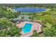 Aerial view of a beautiful community pool, tennis courts, and lake, ideal for recreation and relaxation at 2391 Piedmont Lakes Blvd, Apopka, FL 32703