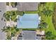 An aerial view shows a light blue roof, lush landscaping and mature palm trees at 2391 Piedmont Lakes Blvd, Apopka, FL 32703