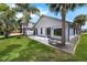 A tranquil backyard view of the home's exterior with palms and verdant grass at 2391 Piedmont Lakes Blvd, Apopka, FL 32703