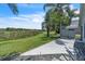 A serene backyard view featuring a patio, lush lawn, palm trees, and a tranquil pond at 2391 Piedmont Lakes Blvd, Apopka, FL 32703