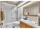 Bathroom with a tiled shower, vanity, and a large mirror reflecting a patterned wallpaper at 2391 Piedmont Lakes Blvd, Apopka, FL 32703