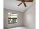 Sunlit bedroom with tiled floor, ceiling fan, and large window, providing natural light at 2391 Piedmont Lakes Blvd, Apopka, FL 32703