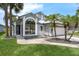Charming single-story home featuring a two-car garage, arched window, gray paint, and decorative palm trees at 2391 Piedmont Lakes Blvd, Apopka, FL 32703