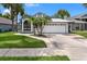 Charming single-story home featuring a two-car garage, arched window, gray paint, and decorative palm trees at 2391 Piedmont Lakes Blvd, Apopka, FL 32703