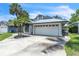 Charming single-Gathering home featuring a metal roof, a two-car garage and lush tropical landscaping at 2391 Piedmont Lakes Blvd, Apopka, FL 32703