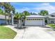 Charming single-Gathering home featuring a metal roof, a two-car garage and lush tropical landscaping at 2391 Piedmont Lakes Blvd, Apopka, FL 32703
