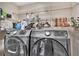 Laundry room with modern washer and dryer units and wire shelving with supplies at 2391 Piedmont Lakes Blvd, Apopka, FL 32703