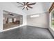 Bright living room with gray tile floors, ceiling fan, and an entrance to a carpeted area at 2391 Piedmont Lakes Blvd, Apopka, FL 32703