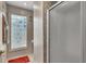 Close-up of a glass door shower with mosaic tiles and a decorative window at 2391 Piedmont Lakes Blvd, Apopka, FL 32703
