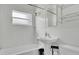 Bathroom features a white pedestal sink, a shower-tub combination, and white tiled walls at 2525 Lafayette Ave, Winter Park, FL 32789