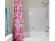 Clean bathroom featuring tiled shower with pink floral curtain at 2550 N Alafaya Trl # 2304, Orlando, FL 32826