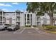 Exterior view of a three story condo with a parking lot, black iron balconies, and well-maintained landscaping at 2550 N Alafaya Trl # 2304, Orlando, FL 32826