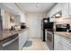 View of the bright kitchen featuring white cabinets, granite countertops, and stainless steel appliances at 2550 N Alafaya Trl # 2304, Orlando, FL 32826