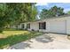Well-kept single-story home with white exterior, attached garage, and concrete driveway at 2710 W County Road 44, Eustis, FL 32726