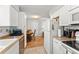 Well-lit kitchen featuring white appliances and cabinetry with a view of the dining area at 2710 W County Road 44, Eustis, FL 32726