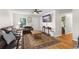 Bright living room with hardwood floors, a large sofa, and view of the front door and hall at 2710 W County Road 44, Eustis, FL 32726