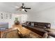 Cozy living room featuring a large leather sofa, ceiling fan, and wood-look flooring at 2710 W County Road 44, Eustis, FL 32726