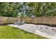 Backyard with lush lawn, privacy fence, landscaping, and stone patio seating at 280 E Bay Ave, Longwood, FL 32750