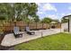 Backyard seating area with elegant stone, loungers, a grill, and privacy fence at 280 E Bay Ave, Longwood, FL 32750