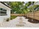 Backyard with patio, landscaped beds, stepping stones, and privacy fence at 280 E Bay Ave, Longwood, FL 32750