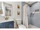 Stylish bathroom featuring a tiled shower with a rainfall showerhead and a blue vanity at 280 E Bay Ave, Longwood, FL 32750