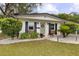 Charming home featuring a lovely light green front door, classic shutters, and beautifully landscaped yard at 280 E Bay Ave, Longwood, FL 32750