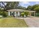 Charming home featuring a lovely light green front door, classic shutters, a covered carport, and beautifully landscaped yard at 280 E Bay Ave, Longwood, FL 32750