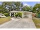 Attractive home exterior with mature trees, lawn, and carport at 280 E Bay Ave, Longwood, FL 32750