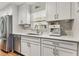 Updated kitchen featuring stainless steel appliances, white cabinets and gray quartz counters at 280 E Bay Ave, Longwood, FL 32750