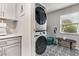 Efficient laundry area features a stacked washer/dryer unit, and a stylish patterned tile floor for easy maintenance at 280 E Bay Ave, Longwood, FL 32750