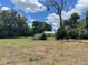 Extensive lot with mature trees and a glimpse of a small house in the background at 31520 Colby Pl, Sorrento, FL 32776