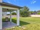 Relaxing backyard features a patio with ceiling fan and large grassy area at 3184 Pinenut Dr, Apopka, FL 32712