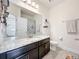 Bathroom featuring dark vanity with granite countertop and a view of the tub/shower combo at 3184 Pinenut Dr, Apopka, FL 32712