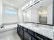 Bathroom featuring a double vanity, soaking tub, and separate shower, combining luxury with modern functionality at 3184 Pinenut Dr, Apopka, FL 32712