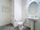 Clean half bathroom featuring pedestal sink, oval mirror, toilet, and modern fixtures at 3184 Pinenut Dr, Apopka, FL 32712