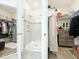 Well-organized bathroom with a glass-enclosed shower, closet, and modern storage shelves, blending style with convenience at 3184 Pinenut Dr, Apopka, FL 32712