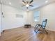 Bright bedroom with hardwood floors, ceiling fan, and a comfortable lounge chair, creating a relaxing space at 3184 Pinenut Dr, Apopka, FL 32712