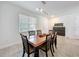 Well-lit dining area features modern lighting, sleek tile flooring, and a dark wood table with matching chairs at 3184 Pinenut Dr, Apopka, FL 32712