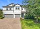 Inviting two-story home featuring a green lawn and a brick driveway, adding to its overall aesthetic appeal at 3184 Pinenut Dr, Apopka, FL 32712